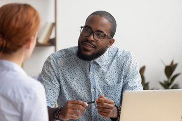 African hr manager listening to caucasian applicant at job interview - obrazy, fototapety, plakaty