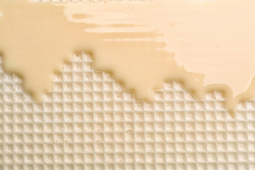 Hot white chocolate on wafer, closeup. Crispy food