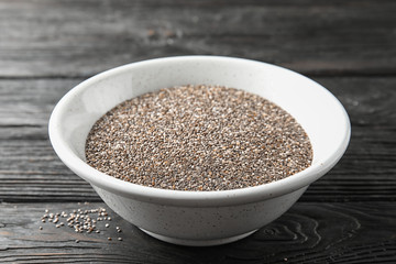 Bowl with chia seeds on wooden background