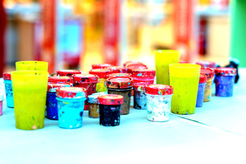 On the white sheet of paper, there are jars of gouache paint