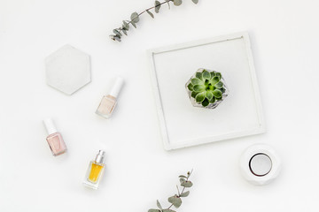 modern design of work desk with nail polish and perfume on white background top view