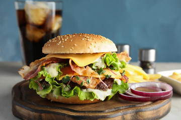 Tasty burger with bacon served on board