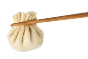Chopsticks with tasty dumpling isolated on white