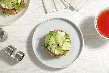 Flat lay composition with traditional English cucumber sandwiches on white wooden background