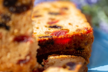 Macro image of a cake slice with fruits. Fruit cake with raisin and grapes. Close-up of sweet muffins with berry. Soft focus. Blurry background. Copy space.