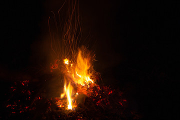 Bonfire in the night, beautiful orange sparkles on a black background.