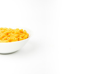 Uncooked macaroni in a bowl isolated on white background with space for text, flat lay concept. 