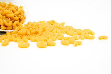 Uncooked elbow macaroni background isolated on white, top view. 