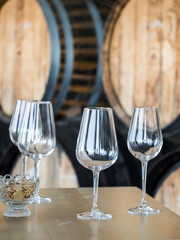 Wine glasses in front of wooden wine barrels