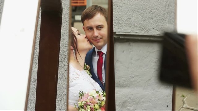 The bride kisses the groom in the mirror