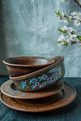 A set of old ceramic tableware. A set of plates, bowls. A branch of apricots. Dark wooden background.