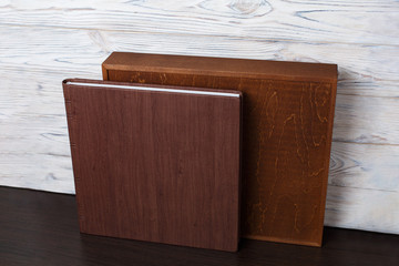 wedding photo book with wooden box. cardboard box for a family photo album. Box for wedding album on the wooden background. Gift box with lid.