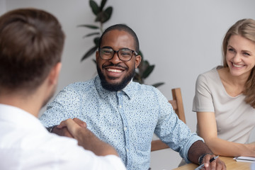 Happy african hr recruit handshake hire candidate at job interview