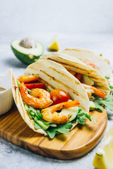 Tortilla tacos with arugula, lemon, avocado and grilled shrimp pawns.
