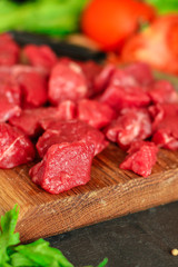 raw meat sliced, cut pieces on a cutting board, fresh. top view. food background