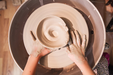 young potter hands working with clay on pottery wheel