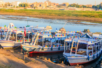 Tourist boats moored near the shore of Nile river in Luxor, Egypt