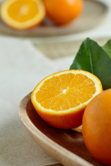 Oranges with leaves in a wooden bowl