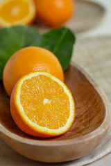 Oranges with leaves in a wooden bowl