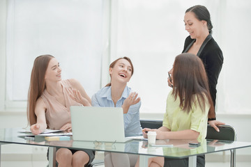 Fototapeta premium employees reading good news on line in a laptop sitting in a desktop at office