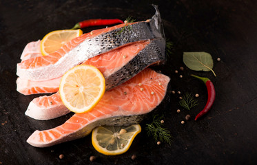 Raw salmon fish fillet on black background