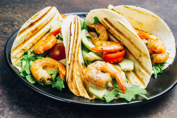 Tortilla tacos with arugula, lemon, avocado and grilled shrimp pawns.