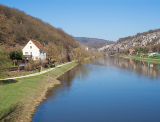 Fototapeta na wymiar view on river Berounka from pedestrial bridge in village Srbsko in central Bohemian region on on spring sunny day, blue sky