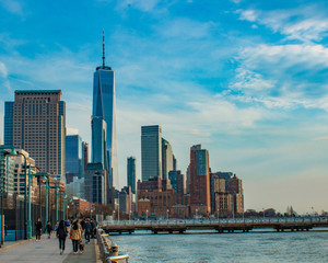 early spring view of one world trade center and financial district from water front against blue sky