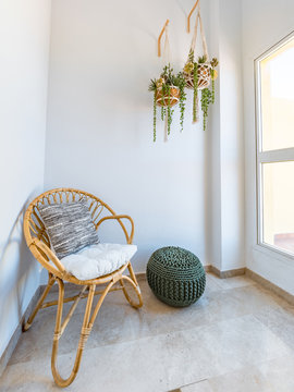 Room Interior With Rattan Chair With Cushion, Macrame Hanging Plants And Fiber Pouf In A Living Room With A Big Window. Lecture Retreat Room. Boho Style Relaxation Decoration Concept.