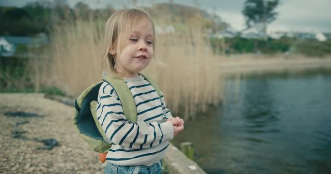 Little toddler throwing rocks in a pond
