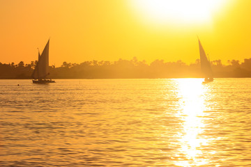 Fototapeta na wymiar View of the Nile river with sailboats at sunset in Luxor, Egypt
