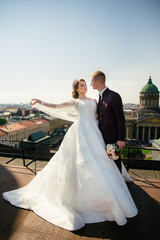 Bride and Groom on Wedding Day in city on roof in St. Petersburg.