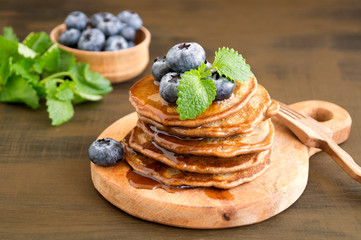 Chocolate pancakes with blueberries on a dark background.