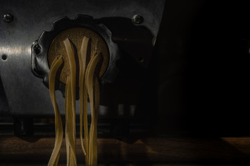 Professional pasta maker machine in working procces in restaurant kitchen