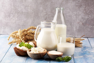 milk products. tasty healthy dairy products on a table. sour cream in a white bowl, cottage cheese bowl, cream in a a bank and milk jar, glass bottle and in a glass