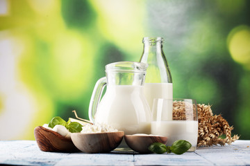 milk products. tasty healthy dairy products on a table. sour cream in a white bowl, cottage cheese bowl, cream in a a bank and milk jar, glass bottle and in a glass
