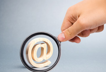 Magnifying glass is looking at the Email icon on gray background. internet correspondence,...