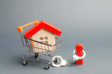 A person is handcuffed to a house on a supermarket cart. The concept of a large debt on a loan or...