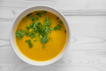 chicken curry soup garnished with cilantro in a ceramic bowl