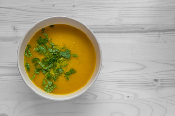 chicken curry soup garnished with cilantro in a ceramic bowl