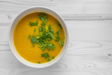 chicken curry soup garnished with cilantro in a ceramic bowl