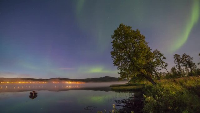 Northern light (aurora borealis) over a lake with fog
