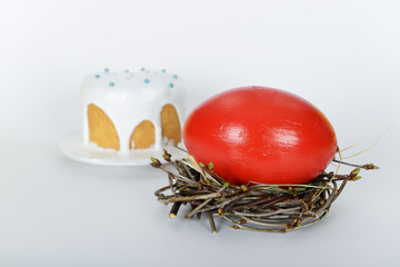 The nest with big red painted ostrich easter egg and traditional easter cake