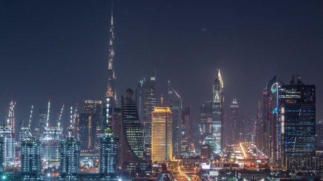 Dubai skyline after sunset with beautiful city center lights and Sheikh Zayed road traffic day to night transition timelapse. Illuminated towers and skyscrapers aerial view from zabeel district. Dubai
