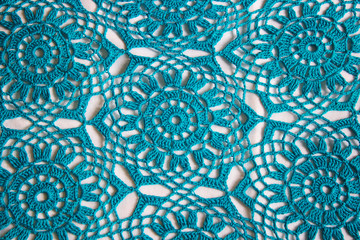 Background knitted lace turquoise handmade on white background.