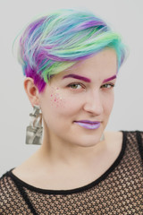 Young beautiful woman with dyed blue and green hair. Pixie bob short haircut The concept of hair styling.