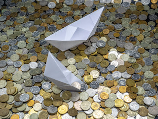 White paper boats in sea made from coins: sailing and sinking. Two different origami ships: one has...