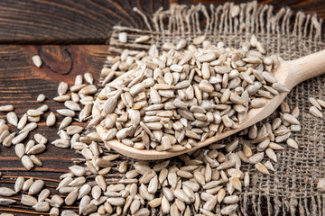 Sunflower seeds on dark wooden background.