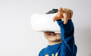 Glasses VR used by a child. Concept of new technology, virtual reality. The child is watching the world through VR glasses. Expression and emotions of a child using googles VR.