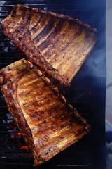 pork ribs on the grill cooking coals / fresh meat pork cooked on charcoal, summer home cooked meal, grilled ribs
